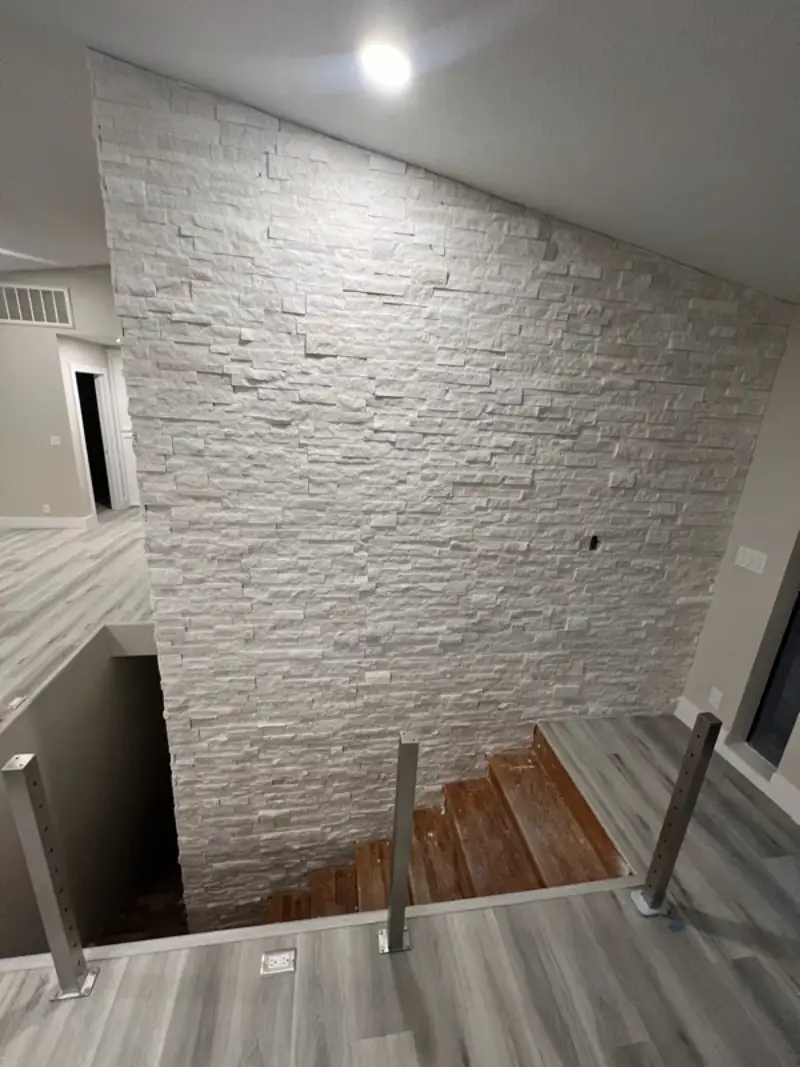 Stacked stone chimney beside an open staircase
