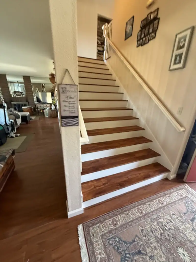 Staircase with wood treads and white risers off the entry